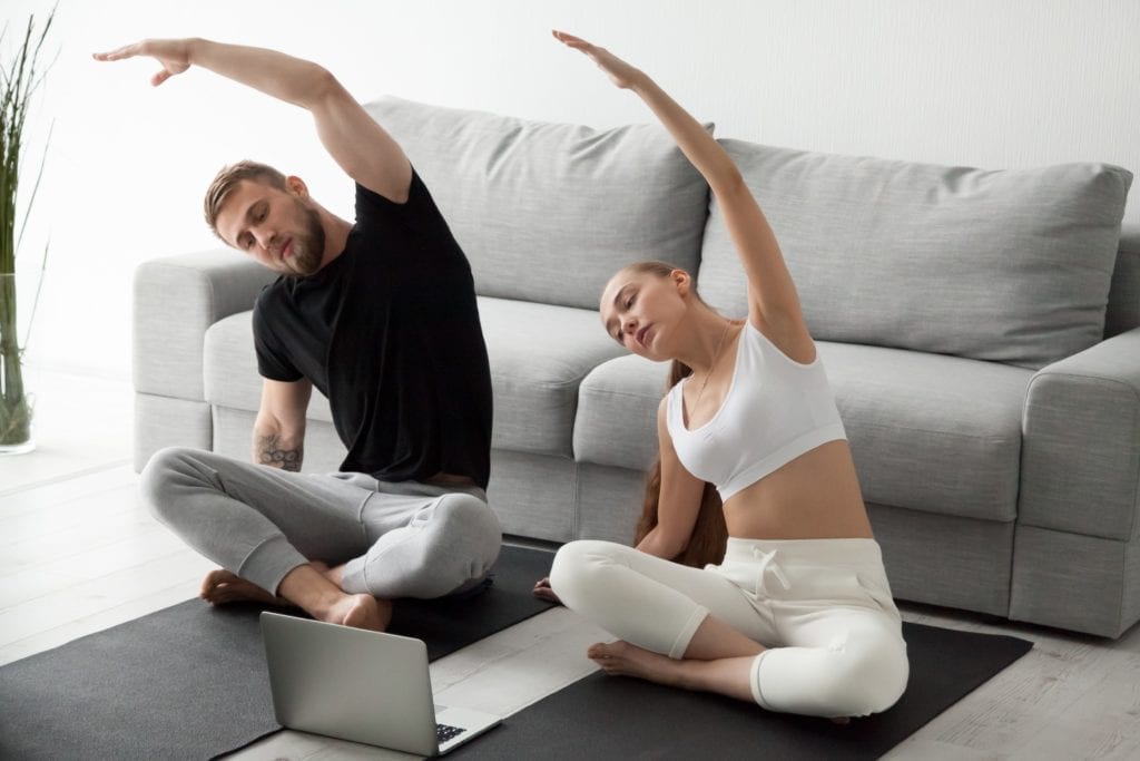 Couple stretching in front of laptop